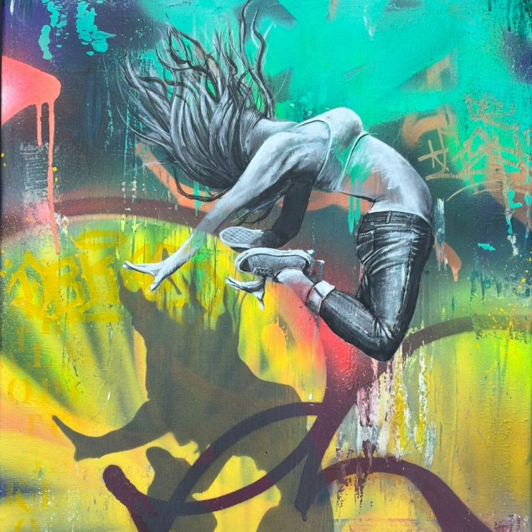 Un jeune homme en train de sauter devant un graffiti coloré.