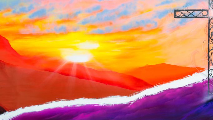 Paysage coloré au coucher de soleil, avec des montagnes et un ciel vibrant.