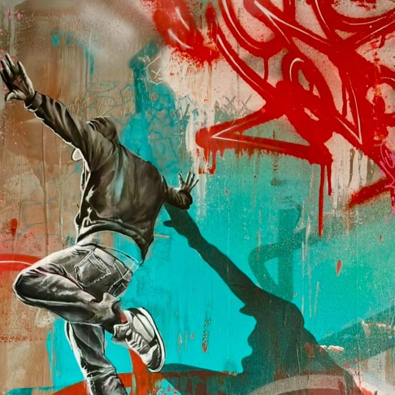Un jeune homme en train de sauter devant un graffiti coloré.
