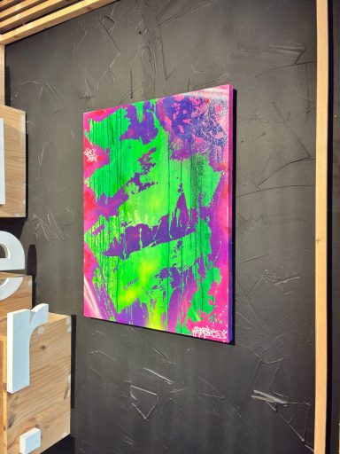 Peinture abstraite aux teintes vives de vert, rose et violet sur fond sombre.