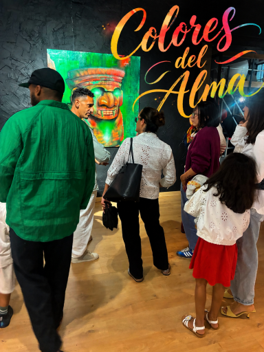 Groupe de personnes devant une œuvre d'art intitulée "Colores del Alma".